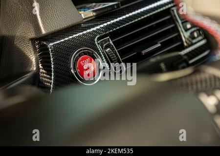 Red engine start button detail. Car dashboard with focus on red engine start stop button, car interior details. button engine start and engine stop, C Stock Photo