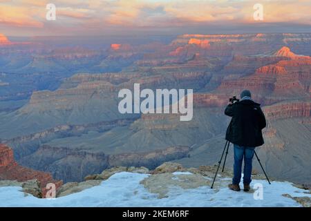 Photographer at the Grand Canyon at sunrise in winter, from Hopi Point, Grand Canyon National Park, Arizona, USA Stock Photo