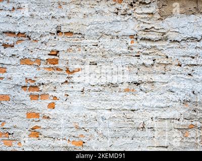 Abstract white grunge peeling cement texture on brick wall background. Old crack plaster concrete wall. Broken stonewall wallpaper. Stock Photo