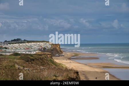 From the coast path, the beaches of the North Norfolk coastline near Cromer. A large caravan holiday park appears on the left. Taken on a sunny day at Stock Photo