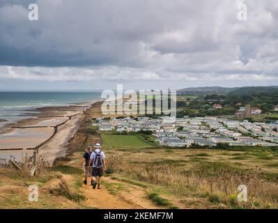 From Beeston Bump a view of the North Norfolk Coast to Cromer. Two walkers and a coast caravan holiday park are visible. Stock Photo