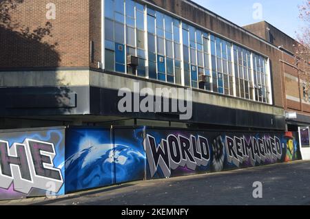 13th November 2022, Swansea, Wales, United Kingdom. A disused shop building and art-covered fence in Swansea City Centre. Stock Photo