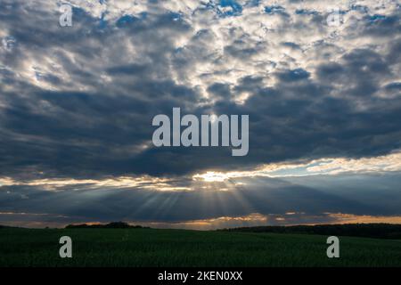 Rays of the setting sun through clouds near the city of Krakow. Poland, Europe. Stock Photo