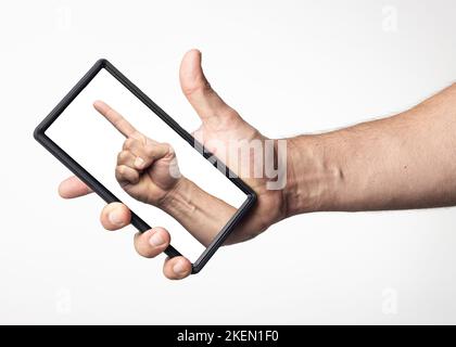 Photomontage showing a hand inside a cell phone screen held by another hand, white background. Stock Photo