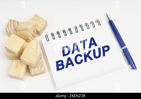 Internet and security concept. On the table are cubes, a pen and a notebook with the inscription - Data Backup Stock Photo