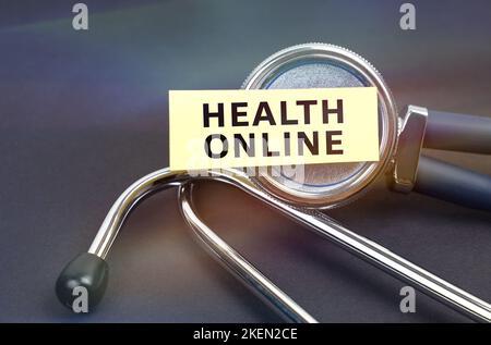 Medicine concept. On a black background, a stethoscope, on which a sticker with the inscription - HEALTH ONLINE Stock Photo