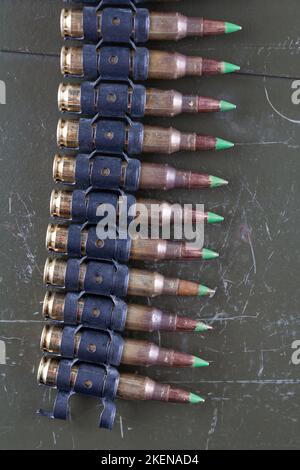 5.56mm ammunition belt with cartridges isolated on green box background Stock Photo