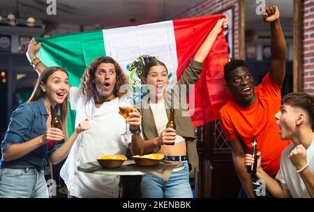 Joyful fans of the Mexican team celebrating the victory in night bar Stock Photo