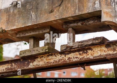 Broken wooden supports of metal beams of the bridge engineering structure. Breaking of construction laws and the risk of the bridge collapsing Stock Photo