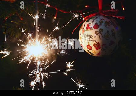 Sparkler burning on a Christmas tree.Christmas tree decoration and sparkler close-up Stock Photo