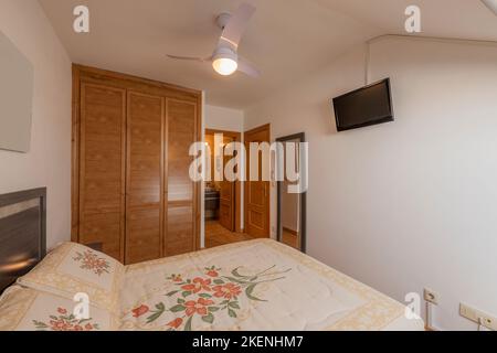 Classic style bedroom with built-in wardrobe with Venetian-style wooden doors Stock Photo