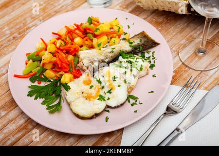 Oven baked hake with vegetable garnish Stock Photo