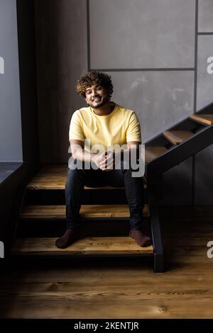 Low angle man sitting on stairs at home Stock Photo