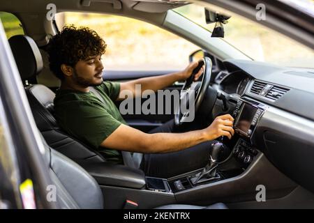Man is going to drive, looking for some nice music Stock Photo