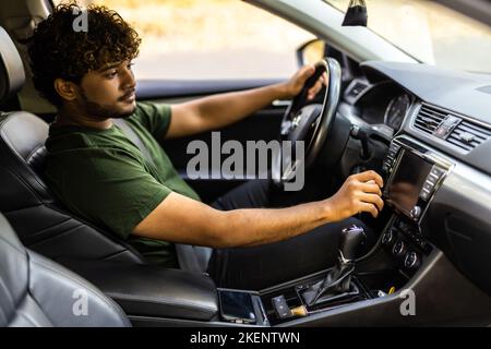 Man is going to drive, looking for some nice music Stock Photo