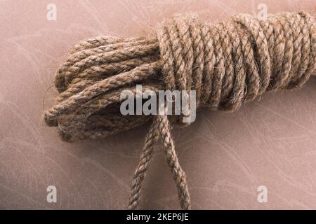 Bundle of linen rope in a sbrown background Stock Photo - Alamy