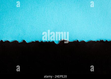 Torn half sheet black paper horizontal on blue paper at the bottom. As template for message or advertisement. Stock Photo