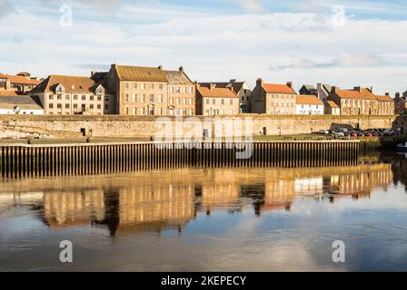 Buildings and town walls reflected in the river Tweed, in Berwick upon Tweed, Northumberland, England, UK Stock Photo