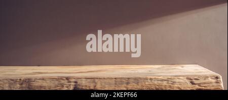 Wooden shelf on a background of beige wall in the sunlight Stock Photo