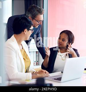 Explaining her vision. three business colleagues working in the office. Stock Photo