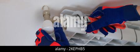 Plumber with wrench is working and installing heating system in apartment Stock Photo