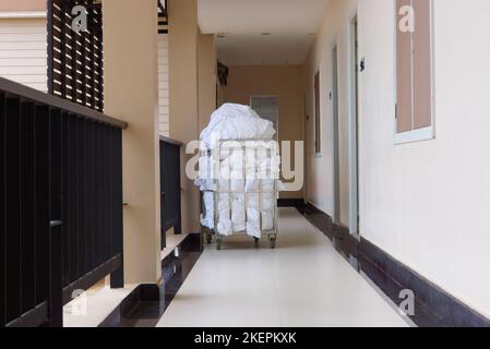 A laundry cart full of dirty linen sits in a hotel corridor in Thailand. Stock Photo