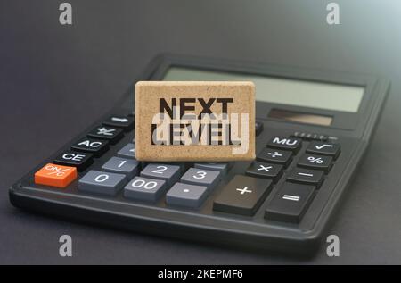 Business concept. There is a sign on the calculator that says - NEXT LEVEL Stock Photo