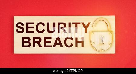 Business concept. On a red background there is a small plaque on it with a lock and an inscription - SECURITY BREACH Stock Photo