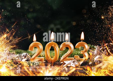Holiday background Happy New Year 2023. Numbers of year 2023 made by gold burning candles on bokeh festive sparkling background. celebrating New Year Stock Photo