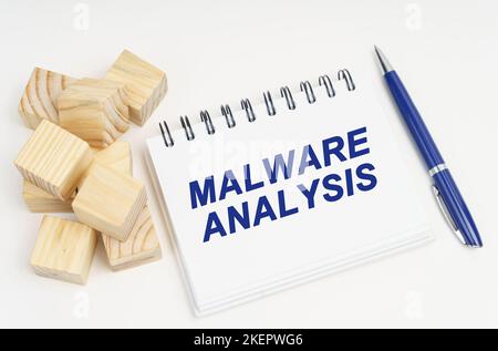 Internet and security concept. On the table are cubes, a pen and a notebook with the inscription - Malware Analysis Stock Photo