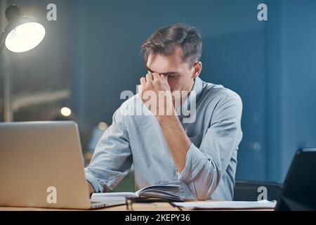 tired young businessman taking notes in his notebook. Stock Photo