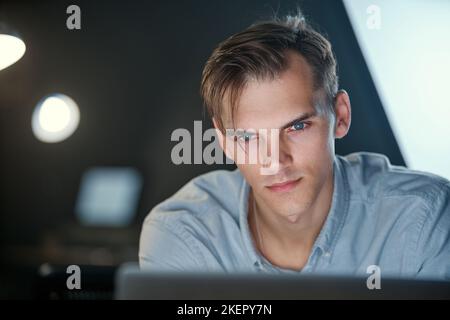 serious young man working on a laptop . Stock Photo