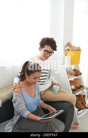 Young Asian couple watching videos on tablet computer Stock Photo