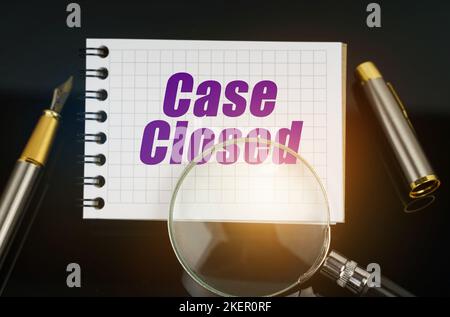 Business and Economics. On the black surface is a pen, a magnifying glass and a notebook with the inscription - Case Closed Stock Photo
