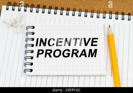 Business and economy concept. There are two notebooks and a pencil on the table. On the top notepad, the inscription - Incentive Program Stock Photo