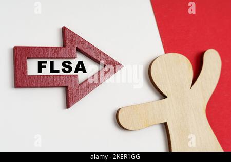 Economy and business concept. On a red-white surface, a human figure and an arrow with the inscription - FLSA Stock Photo