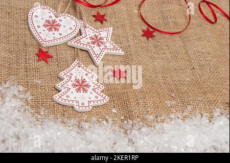 Wooden Christmas decorations on a background of burlap with artificial snow Stock Photo