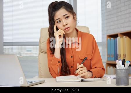 Pensive pretty business woman thinking about ideas for new project Stock Photo