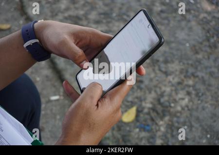 Close up business hand holding and operating smart phone device in the nature. modern technology for communication Stock Photo