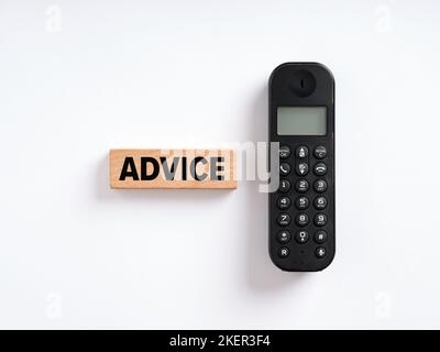 The word advice on wooden block with a wireless phone. Online support service, assistance or help concept. Stock Photo