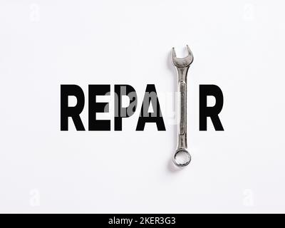 The word repair written with a wrench. To repair or fix something broken, maintenance service business concept. Stock Photo