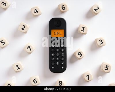 Retro wireless phone or telephone with the word dial on the screen with numbers around it. Dialing a phone number or call concept. Stock Photo