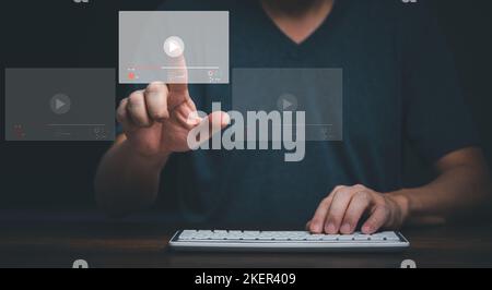 Young man using computer and touching on virtual screen online streaming video on internet. Stock Photo
