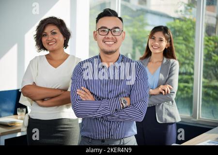 Portrait of young successful business team standing with arms crossed Stock Photo