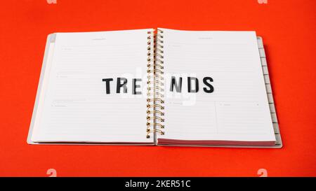Technology Trends, Tech trends, Top New Technology. Word trends on open notepad with different gadgets and devices on red background. Stock Photo
