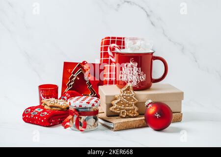 Sustainable christmas Gifts, Eco-Friendly Holiday Xmas Gift Ideas. Red and brown zero waste cup, shopper bag, socks, notepad, sweets, cookies on table Stock Photo