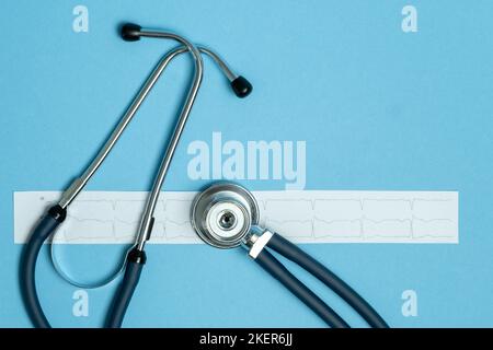 Stethoscope and cardiogram results on blue background. Health care and surgical concept. Stock Photo