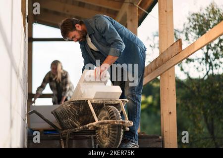 Mature man working on construction site of their new house. Stock Photo