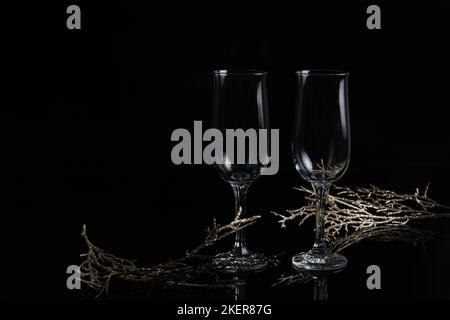 Two empty glasses of champagne and Christmas or New Year decoration on a black background. Romantic dinner. Winter holiday concept. Stock Photo