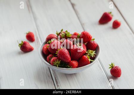 Heap of fresh strawberries in ceramic bowl on white background. Healthy eating and diet food concept. Stock Photo